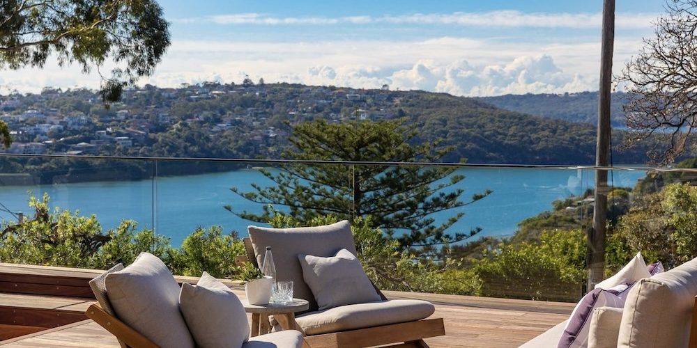 an outside deck with chairs and a view in a Mosman downsizer apartment in Sydney