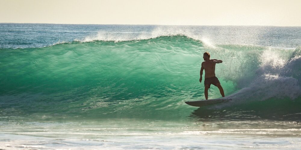 riding a wave on Manly beach - Manly buyers agents