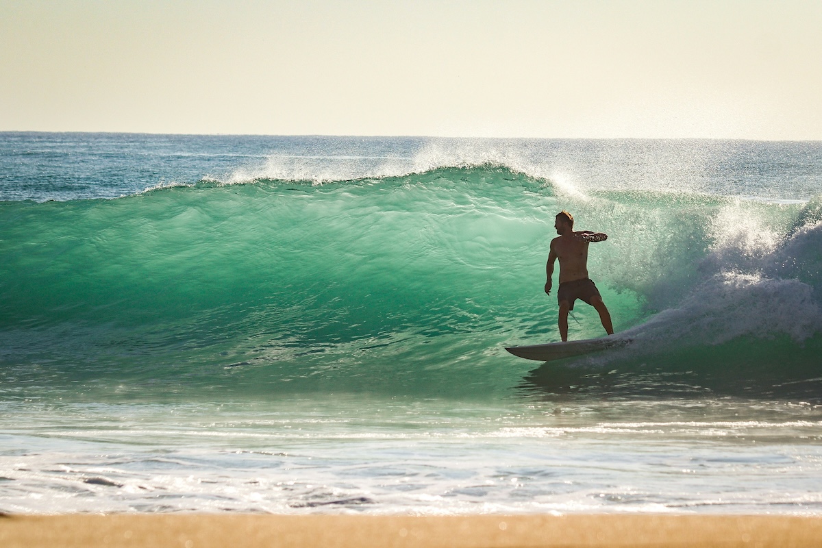 riding a wave on Manly beach - Manly buyers agents