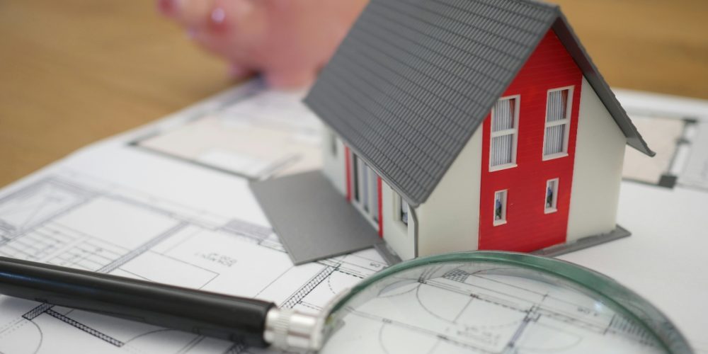 a home on architectural plans with a piggy bank, this is Bernadette Brennan from Premier home finders budget insight into the Australian budget handed down in May 2026