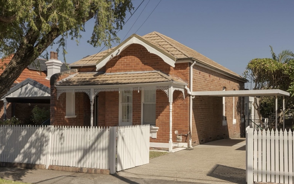 The facade of 133 Duntroon Street, Hurlstone Park, NSW 2193, showing a white picket fence with orange brick- this was the top home sale in in May 2026