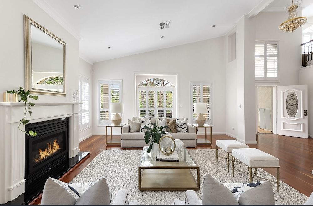 Lounge room with open fire and white lounges and high ceilings this Gordon property on Sydney's Upper North Shore was the top home sale in May 2026