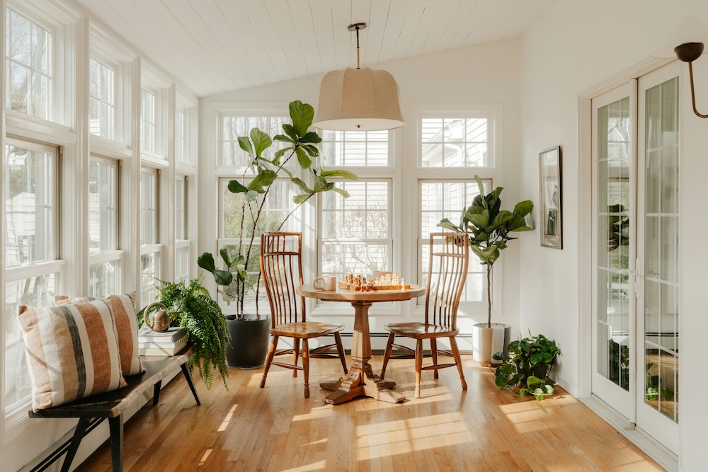 light filled closed in veranda with windows and a table with a chess board on it.