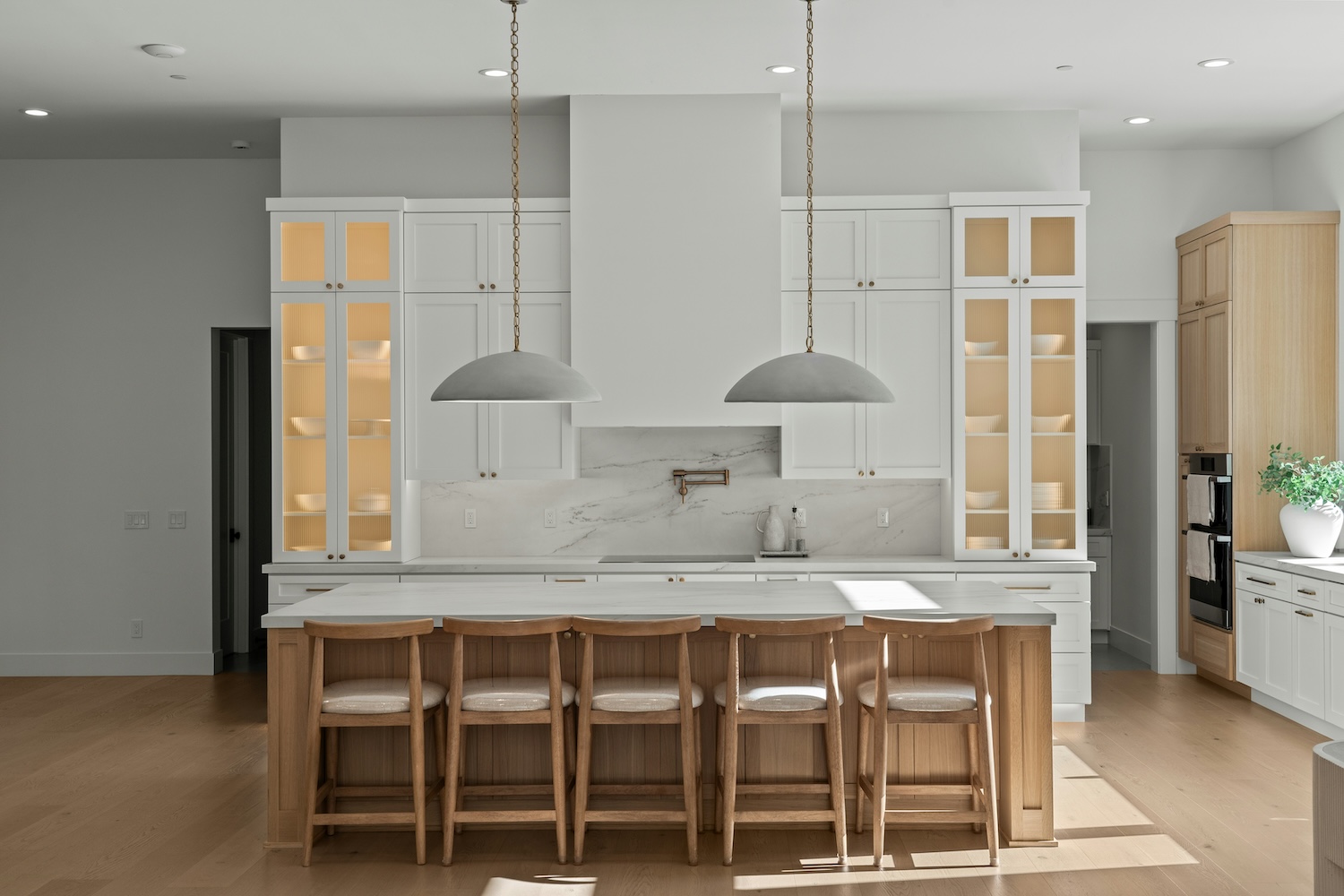 white kitchen with island bench and woodern stools